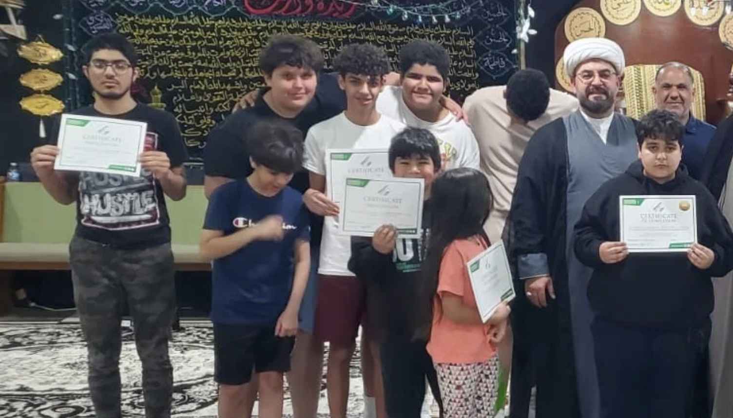 Students holding their certificates with educators at a graduation ceremony